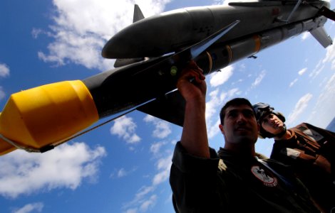 US Navy 070330-N-5345W-009 Lt. Mike Gallieri, a naval aviator assigned to the Raging Bulls of Strike Fighter Squadron (VFA) 37, inspects an AIM-9M Sidewinder missile mounted on his F-A-18C Hornet