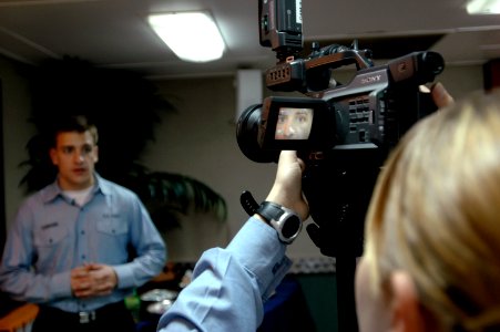 US Navy 070406-N-1635S-005 Mass Communication Specialist Seaman Zachary Hawkins from Virginia Beach, Va., left, rehearses his lines prior to filming a newscast aboard USS Ronald Reagan (CVN 76)