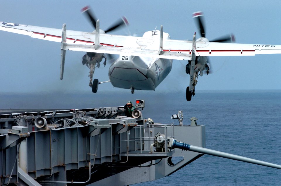 US Navy 070403-N-4420S-067 Aviation Boatswain's Mate (Equipment) 3rd Class Paula Gray covers up as a C2-A Greyhound, from Carrier Logistics Support Squadron (VRC) 30, takes off
