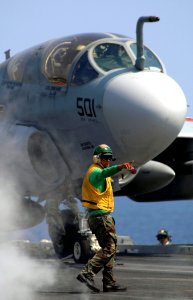 US Navy 070401-N-5345W-098 An air department flight deck supervisor signals to the waist catapults safety observer as an EA-6B Prowler, from the Zappers of Tactical Electronic Attack Squadron (VAQ) 130, stages to launch