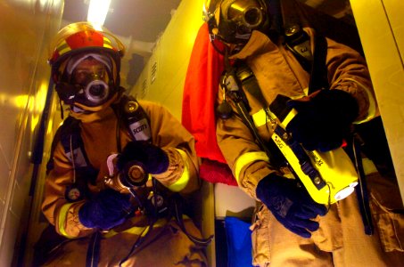 US Navy 070404-N-7130B-187 A firefighting team assigned to the Nimitz-Class aircraft carrier USS Ronald Reagan (CVN 76) Repair Locker Seven Fox (7F) combats a simulated fire during a general quarters drill aboard the ship photo