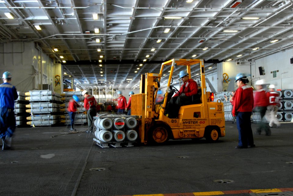 US Navy 070406-N-3659B-086 Using forklifts, aviation ordnancemen stage crates of ordnance in hangar bay two aboard USS Ronald Reagan (CVN 76)