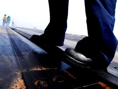 US Navy 070404-N-3729H-092 Sailors attached to air department's launch and recovery division apply the cover to a catapult at the conclusion of flight operations aboard the Nimitz-class aircraft carrier USS John C. Stennis (CVN