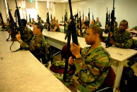 US Navy 070404-N-0775Y-011 Religious Program Specialist Seaman Steven White, assigned to Naval Mobile Construction Battalion (NMCB) 3 holds an M-16 rifle during a weapons training course at Camp Shields