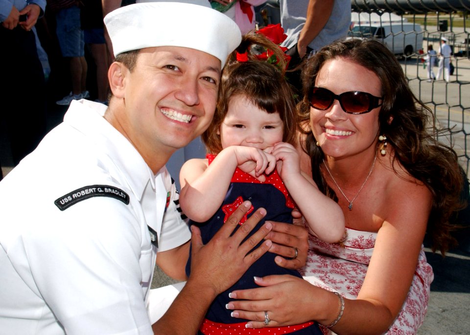 US Navy 070405-N-1810F-152 Gas Turbine System Technician (Mechanical) 1st Class Lee Mears attached to USS Robert G. Bradley (FFG 49), smiles for photos with his wife and his niece after returning from a six-month deployment