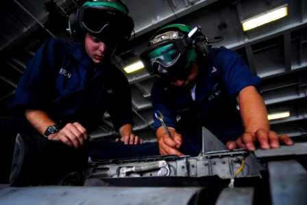 US Navy 070403-N-2659P-054 Aviation Structural Mechanic Airman Joshua Burton, left, and Aviation Structural Mechanic 3rd Class Ricardo Pezaguirre work together to install a wingfold swivel on an F-A-18C Hornet