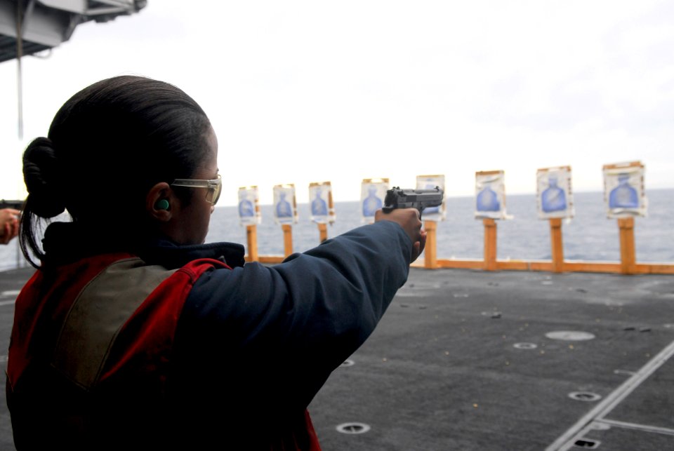 US Navy 070405-N-6326B-001 Chief Electronics Technician Alicia Harrison fires a 9mm handgun during a small arms qualification shoot aboard the nuclear-powered USS Nimitz (CVN 68)