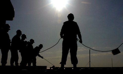 US Navy 070406-N-7130B-080 As the sun shines brightly overhead, Sailors assigned to USS Ronald Reagan (CVN 76) Deck Department tend the phone and distance line, used for bridge-to-bridge communication, as an ammunition offload