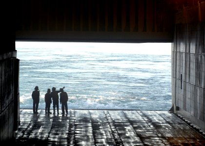 US Navy 070403-N-4954I-166 Boatswain's Mates standby in the well deck as the stern gate of amphibious assault ship USS Peleliu (LHA 5) starts to close after a Landing Craft Air Cushion (LCAC) launches