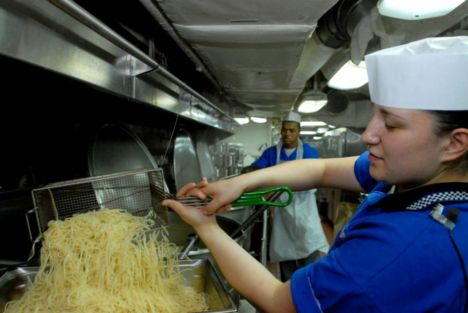 US Navy 070406-N-7730P-043 In the aft galley of Nimitz-class aircraft carrier USS Ronald Reagan (CVN 76), Culinary Specialist Seaman Monica Arias stirs spaghetti noodles, for serving at evening dinner