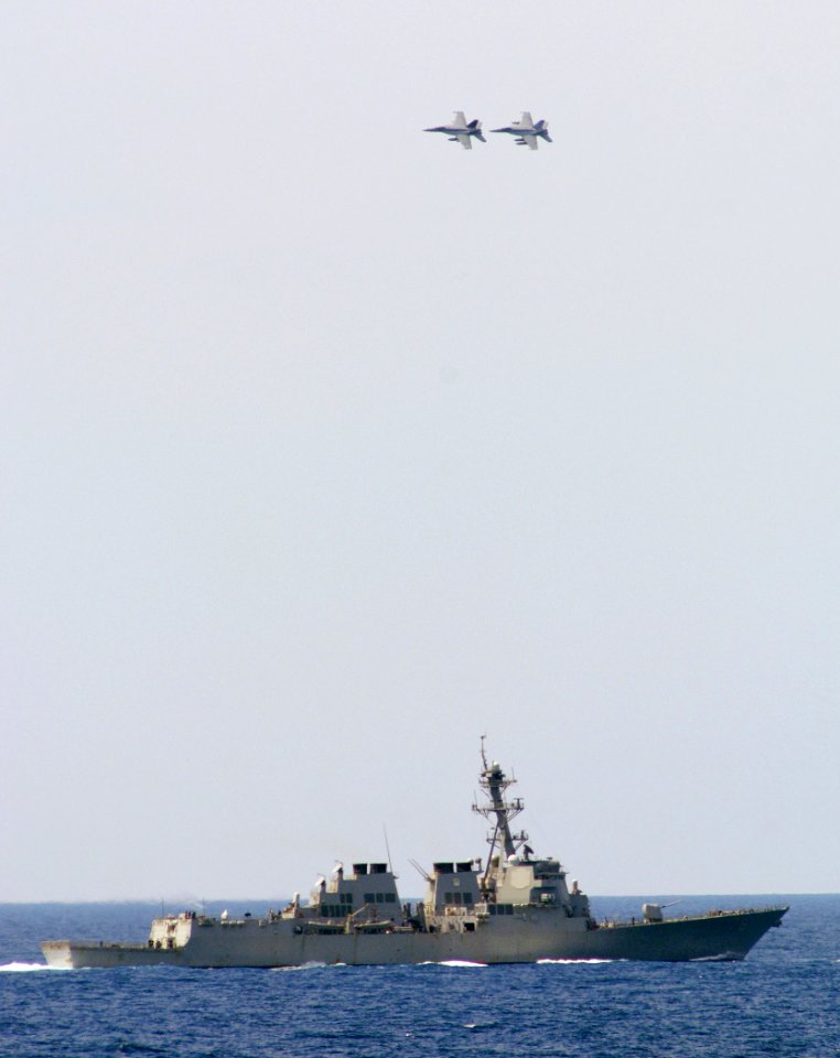 US Navy 070403-N-5345W-171 Two F-A-18F Super Hornets from the Red Rippers of Strike Fighter Squadron (VFA) 11 bank hard in formation over the Arleigh Burke-class guided missile destroyer USS Oscar Austin (DDG 79)