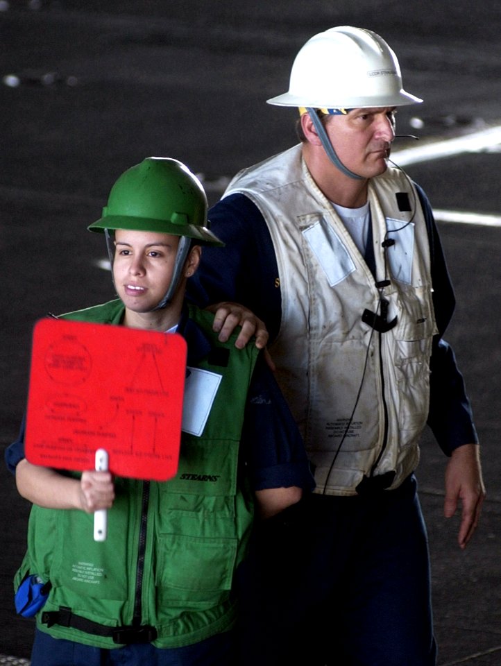 US Navy 070406-N-9712C-014 Boatswain's Mate Seamen Angie Jimenez signals to her counterpart on board Military Sealift Command (MSC) ammunition ship USNS Flint (T-AE 32)