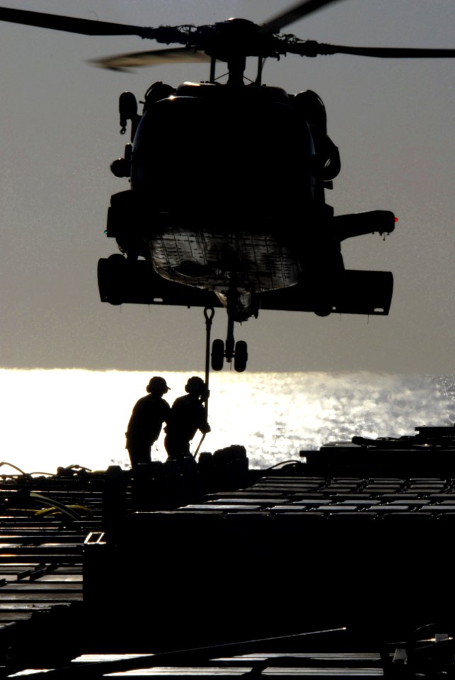 US Navy 070406-N-0555B-037 Aviation ordnancemen attach a sling to an HH-60H Seahawk, assigned to the Black Knights of Helicopter Anti-Submarine Squadron (HS) 4