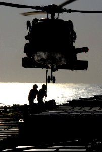 US Navy 070406-N-0555B-037 Aviation ordnancemen attach a sling to an HH-60H Seahawk, assigned to the Black Knights of Helicopter Anti-Submarine Squadron (HS) 4
