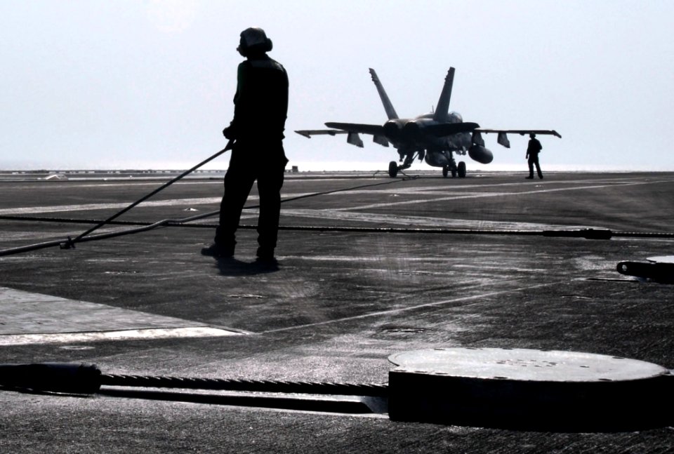 US Navy 070406-N-2659P-154 A Sailor uses a pushback bar to assist with retracting the arresting gear wire after an F-A-18C Hornet, from the Blue Diamonds of Strike Fighter Squadron (VFA) 146, lands aboard Nimitz-class aircraft
