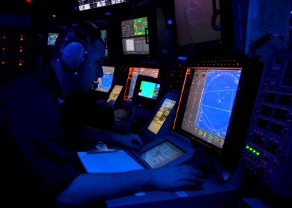 US Navy 070410-N-2659P-005 Operation Specialist 2nd Class Michael Sinnes conducts radio operations during a Search and Rescue (SAR) exercise in the Combat Direction Center (CDC) aboard Nimitz-class aircraft carrier USS John C