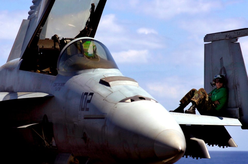 US Navy 070406-N-7130B-232 Resting on the wing of an F-A-18E Super Hornet Aviation Electrician's Mate 1st Class Daniel Castillo, from Avon Lake, Ohio, waits for the rest of his crew to arrive to begin routine maintenance on the