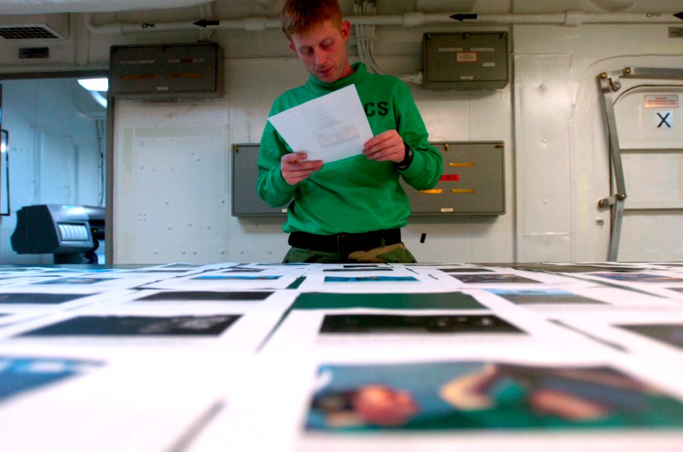 US Navy 070406-N-7130B-029 In the photo lab aboard USS Ronald Reagan (CVN 76), Mass Communication Specialist 2nd Class John Curtis, from San Bernardino, Calif., edits images and captions