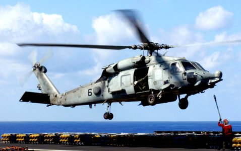 US Navy 070406-N-7130B-510 An HH-60H Seahawk assigned to the Black Knights of Helicopter Anti-Submarine Squadron (HS) 4 hovers as a pair of aviation ordnancemen prepare to attach a load of ordnance that will be tr