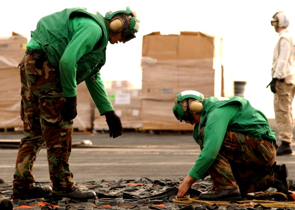 US Navy 070411-N-6854D-006 Sailors tie up cargo nets used during an underway replenishment aboard the Nimitz-class aircraft carrier USS Dwight D. Eisenhower (CVN 69)