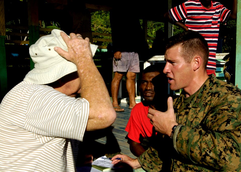 US Navy 070414-N-4790M-006 USMC liaison officer talks local officials regarding relief efforts for tsunami victims in Solomon Islands