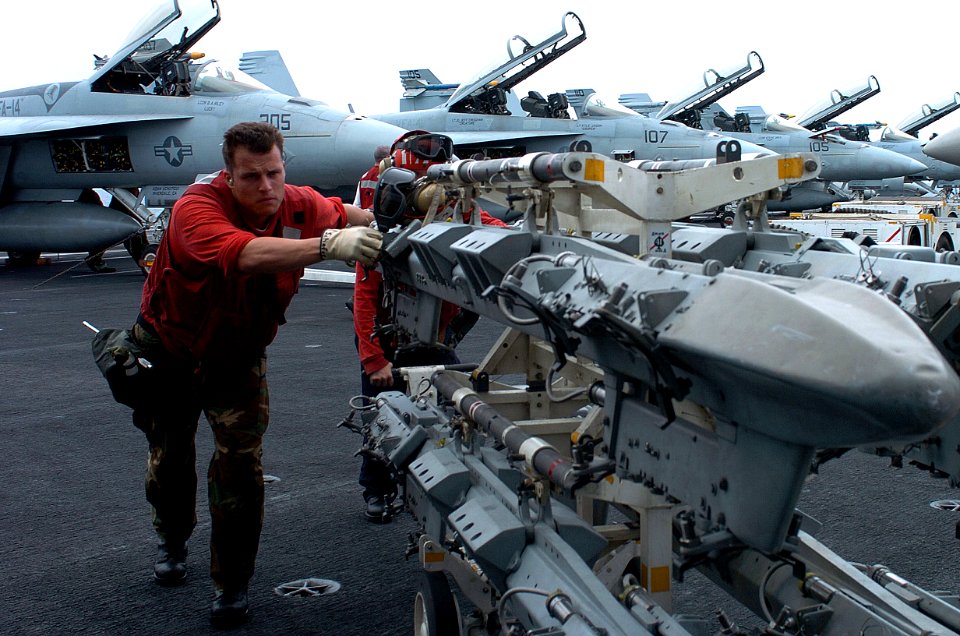 US Navy 070410-N-4420S-001 Aviation Ordnanceman 3rd Class Alexis Scheffer pushes an ordnance rack on the flight deck aboard the nuclear-powered aircraft carrier USS Nimitz (CVN 68)