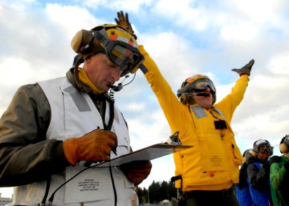 US Navy 070410-N-7981E-073 Senior Chief Aviation Boatswain's Mate John Marcella, a member of the Air Department Training Team, evaluates flight deck personnel as they respond to a simulated crash