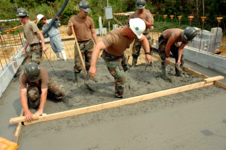 US Navy 070416-N-0775Y-022 Chief Builder James Dolan uses his boots to level concrete that has recently been poured onto the floor of a storage facility