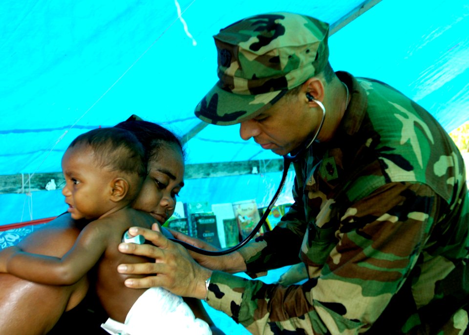 US Navy 070416-N-4790M-135 Lt. Cmdr. Karlwin Matthews provides medical assistance to a child in Titiana