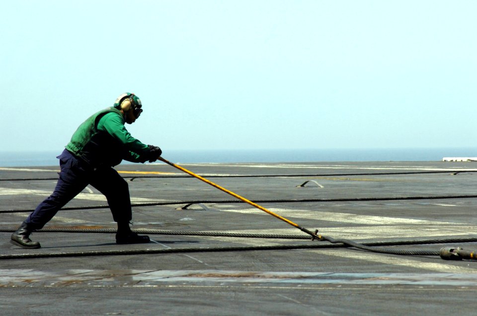 US Navy 070413-N-8907D-002 An arresting gear operator pushes back an arresting wire on the flight deck of Nimitz-class aircraft carrier USS Dwight D. Eisenhower (CVN 69)