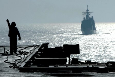 US Navy 070414-N-2659P-077 A Sailor from supply department signals for assistance to transport supplies received aboard the Nimitz-class aircraft carrier USS John C. Stennis (CVN 74)