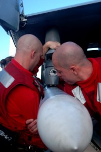 US Navy 070414-N-5484G-018 Aviation Ordnancemen 2nd Class Mark Everett and 3rd Class Trevor Polock load a Sea Sparrow anti-air missile on the wing of an F-A-18E Super Hornet