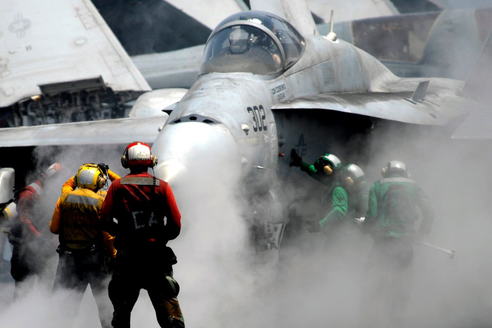US Navy 070413-N-8157C-210 A flight deck director motions an F-A-18C Hornet, from the Blue Diamonds of Strike Fighter Squadron (VFA) 146, onto catapult one aboard Nimitz-class aircraft carrier USS John C. Stennis (CVN 74)