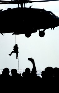 US Navy 070415-N-0555B-041 Demonstrating the quick insertion techniques used for visit, board, search and seizure (VBSS), a member of Explosive Ordnance Disposal Mobile Unit (EODMU) 11 Detachment 15 fast-ropes from an HH-60H Se photo