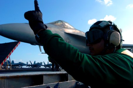 US Navy 070420-N-4420S-137 Aviation Boatswain's Mate Equipment 1st Class Juan Salcido raises a finger to signal the catapult is ready to be fired aboard the nuclear-powered aircraft carrier USS Nimitz (CVN 68)