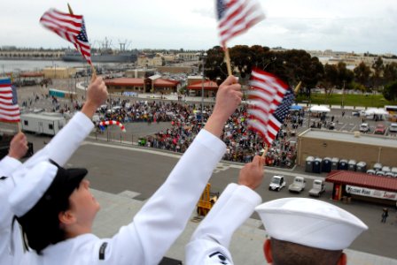 US Navy 070420-N-3659B-157 Sailors wave American flags on the starboard side of USS Ronald Reagan (CVN 76) while manning the rails as the ship pulls into homeport photo