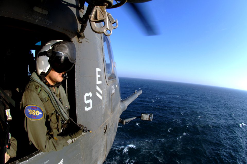 US Navy 070416-N-6501M-016 Aviation Warfare Specialist 2nd Class Aaron Ortiz of Westlaco, Texas, observes while an MH-53E Sea Dragon, assigned to Helicopter Mine Counter Measure Squadron (HM) 15, conducts a mine sweeping exerci