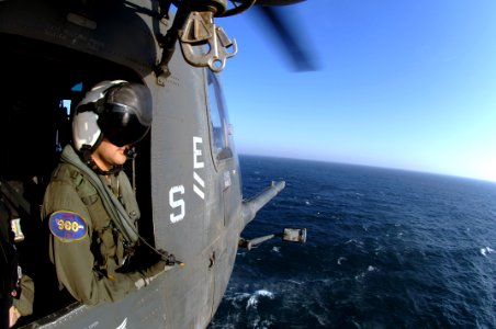 US Navy 070416-N-6501M-016 Aviation Warfare Specialist 2nd Class Aaron Ortiz of Westlaco, Texas, observes while an MH-53E Sea Dragon, assigned to Helicopter Mine Counter Measure Squadron (HM) 15, conducts a mine sweeping exerci