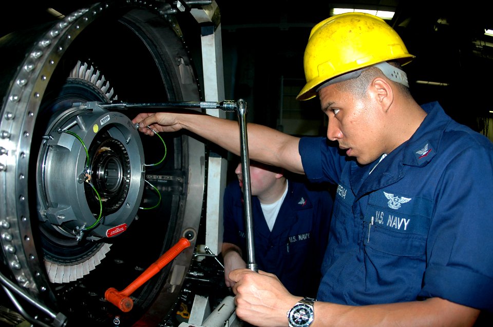 US Navy 070413-N-9760Z-014 Aviation Machinist's Mate 3rd Class Enrique Mairena works on the shaft of an F-A-18C Hornet engine aboard the nuclear-powered aircraft carrier USS Nimitz (CVN 68)