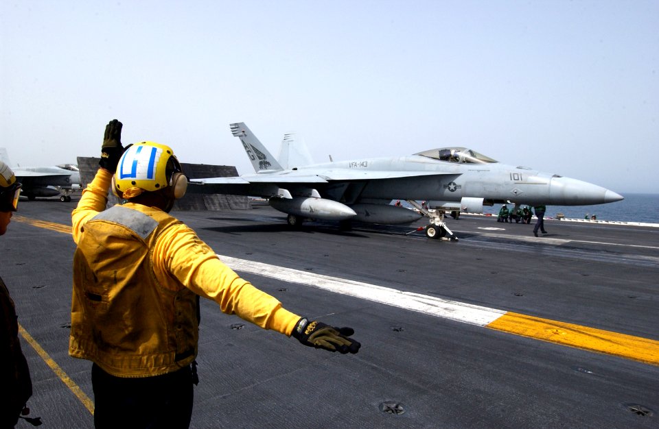 US Navy 070423-N-6854D-002 A plane director signals to the pilot of an F-A-18E Super Hornet, from the Pukin Dogs of Strike Fighter Squadron (VFA) 143
