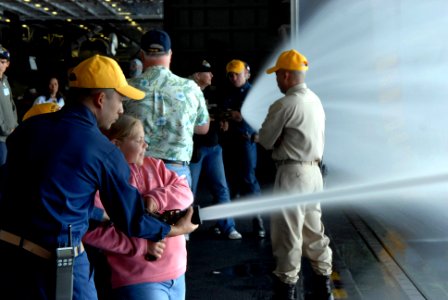 US Navy 070417-N-3659B-298 Chief Storekeeper Eugene Chua, a member of the Damage Control Training Team aboard USS Ronald Reagan (CVN 76), teaches fire hose handling techniques to a young Tiger during tiger general quarters in t