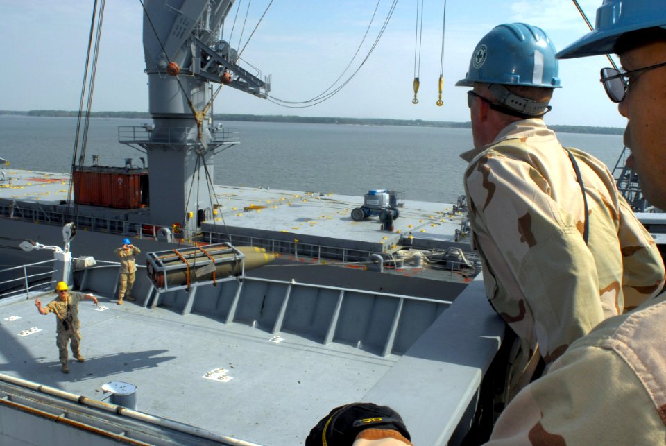 US Navy 070424-N-4515N-032 Storekeeper 2nd Class Rey Decastro, far right, and Boatswain's Mate 2nd Class Ryan Hanke, center, operate a port and stay crane to load cargo onto a simulated vessel