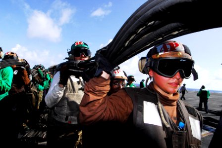US Navy 070418-N-6326B-077 Airman Kim Nigel aids in re-stowing the barricade after a crash and recovery drill aboard nuclear-powered aircraft carrier USS Nimitz (CVN 68)