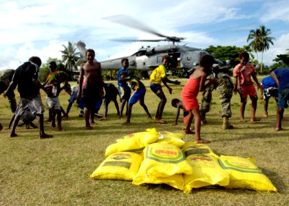US Navy 070419-N-4790M-065 Children from Gizo Island cheer as an HH-60H helicopter takes off from the landing zone after delivering rice in support of humanitarian efforts in the Solomon Islands
