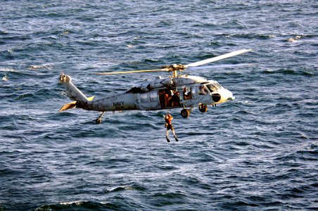 US Navy 070416-N-6501M-020 Navy personnel assigned to the Desert Hawks of Helicopter Sea Combat Squadron (HSC) 26, hoist up a diver to a MH-60S Seahawk while participating in a mine sweeping exercise