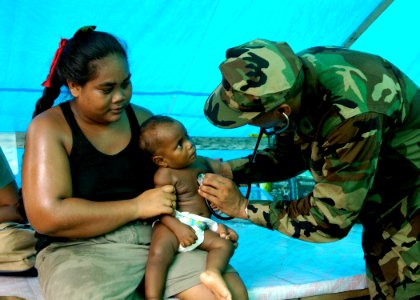 US Navy 070416-N-4790M-128 Lt. Cmdr. Karlwin Matthews provides medical aid to a native child
