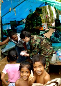 US Navy 070416-N-4790M-119 Lt. Cmdr. Eilene Herrera and Lt Cmdr. Karlwin Matthews provide medical assistance to local families impacted by the recent earthquake and tsunami in the region