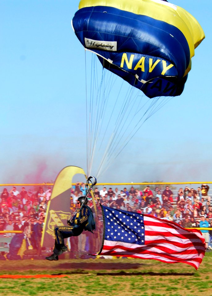 US Navy 070417-N-2903M-013 Chief Special Warfare Operator Larry Summerfield of the Navy Parachute Team delivers the American flag to the football field during a performance at North Bullitt High School