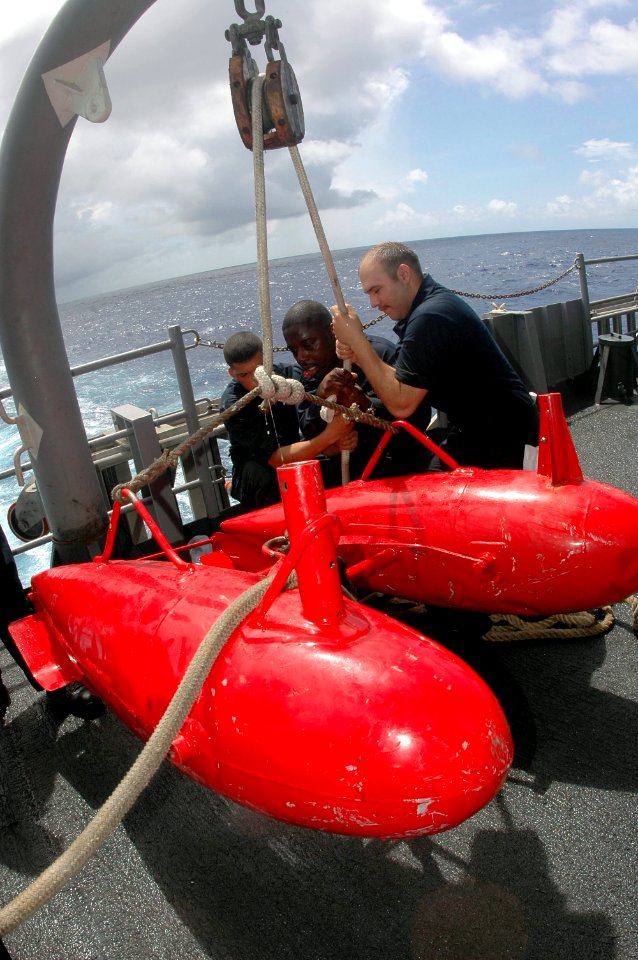 US Navy 070426-N-9760Z-056 Seaman Isaac Martinez and Boatswain's Mate 1st Class Mitchell Simmons pull the rope to lift the target tow sled off the deck during a moving target shooting exercise aboard nuclear-powered aircraft ca
