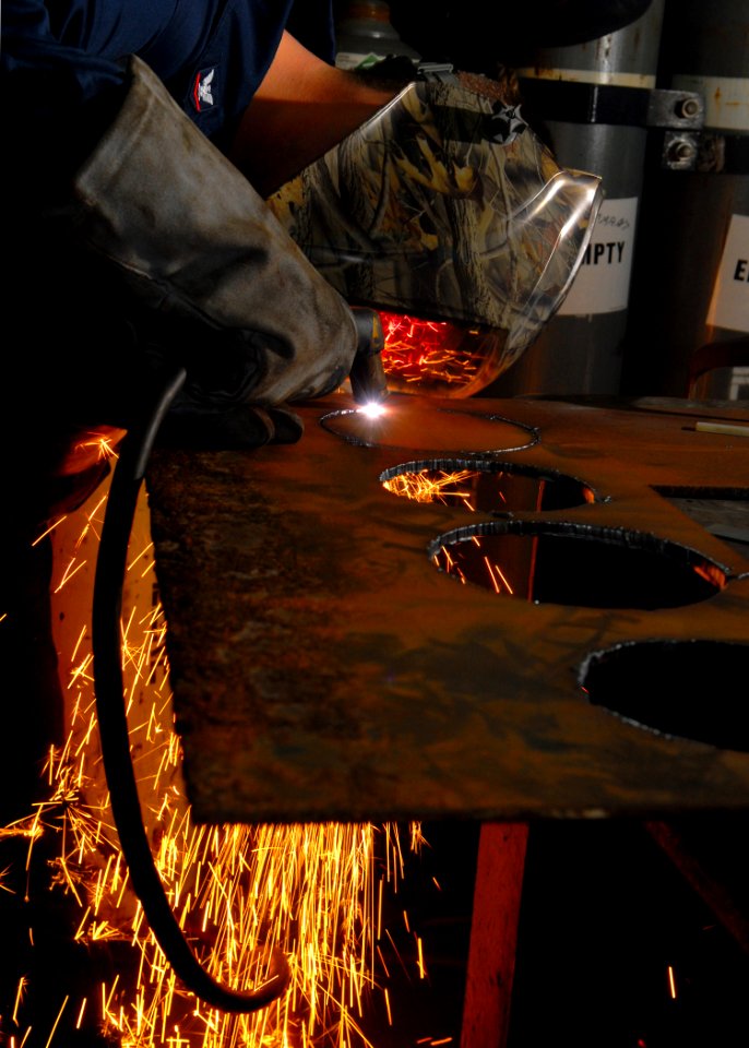 US Navy 070423-N-7981E-096 Hull Maintenance Technician 3rd Class Jeffrey Goodwin uses a plasma cutter to cut flanges for a pressure relief valve aboard Nimitz-class aircraft carrier USS Abraham Lincoln (CVN 72)